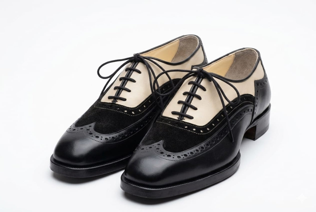 Pair of black leather shoes with white soles on a white background